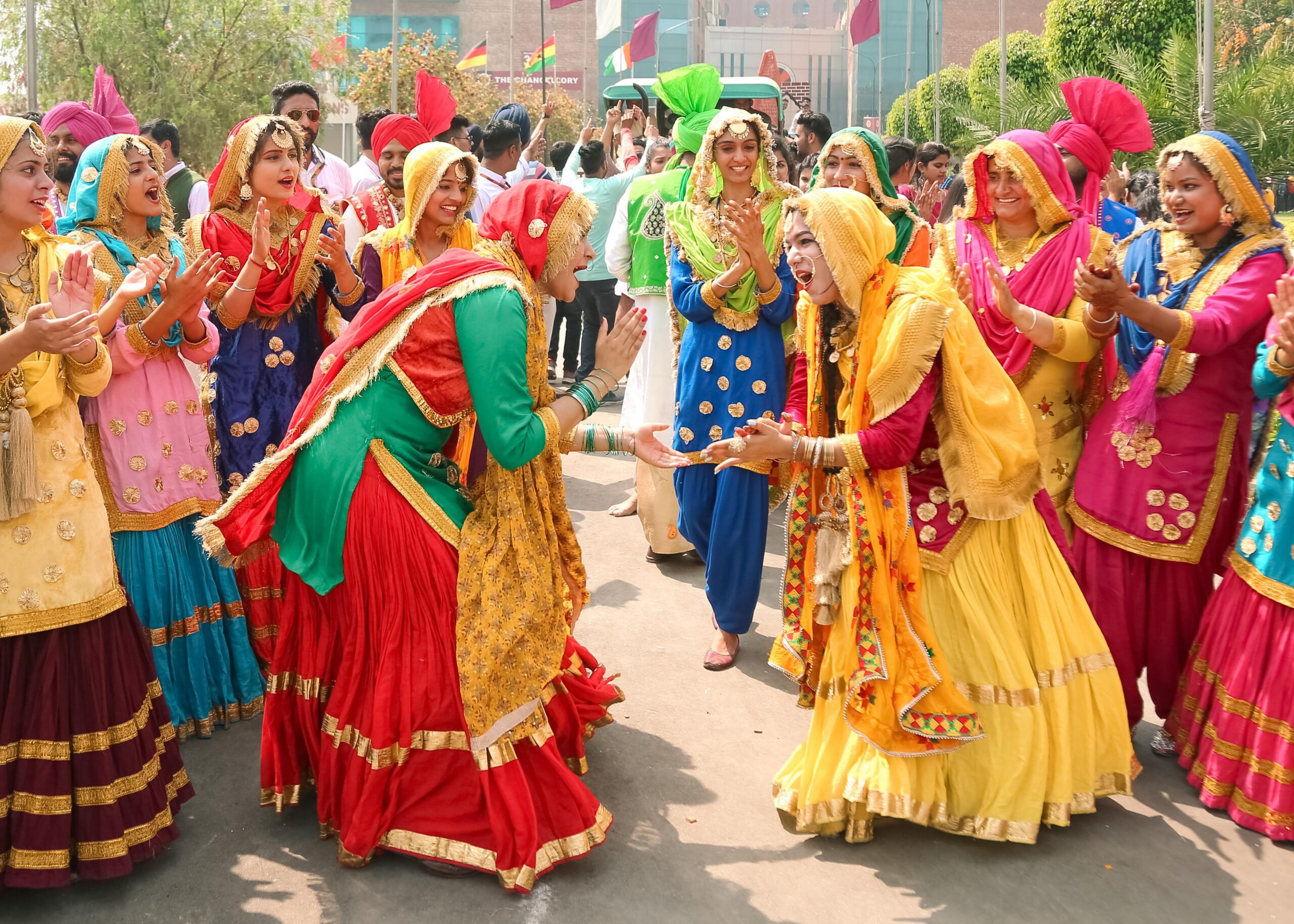 Indian women in colorful traditional clothing dancing in the street during Baisakhi festival