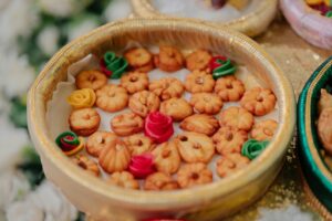 Traditional Indian sweets and colorful decorations arranged in an ornamental festival platter