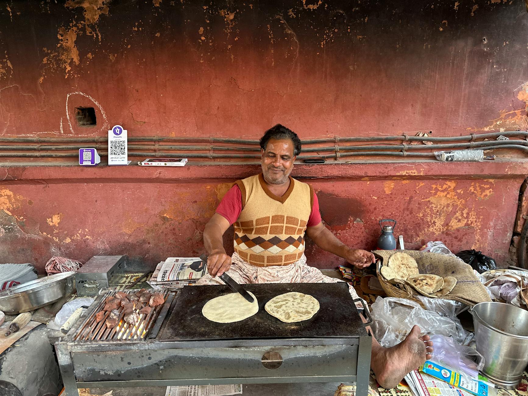 Indian street food vendor cooking flatbreads on a hot griddle