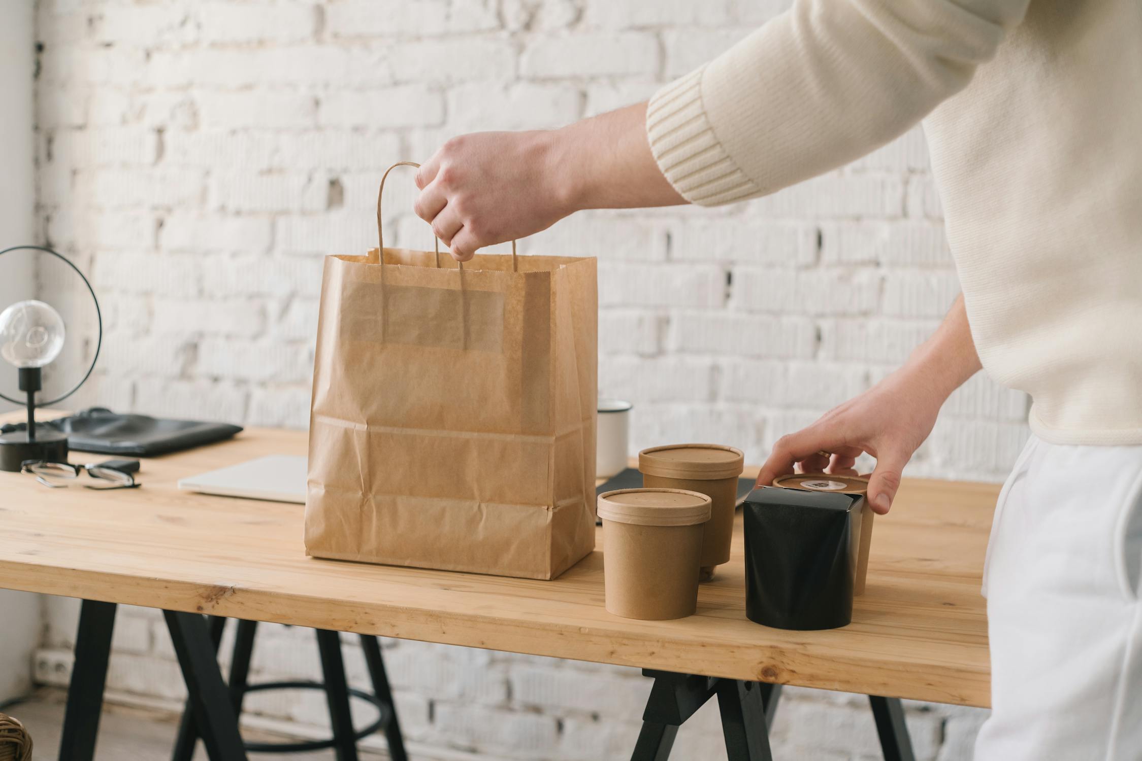 Takeaway food packaging arranged on wooden table showing eco-friendly restaurant packaging solutions