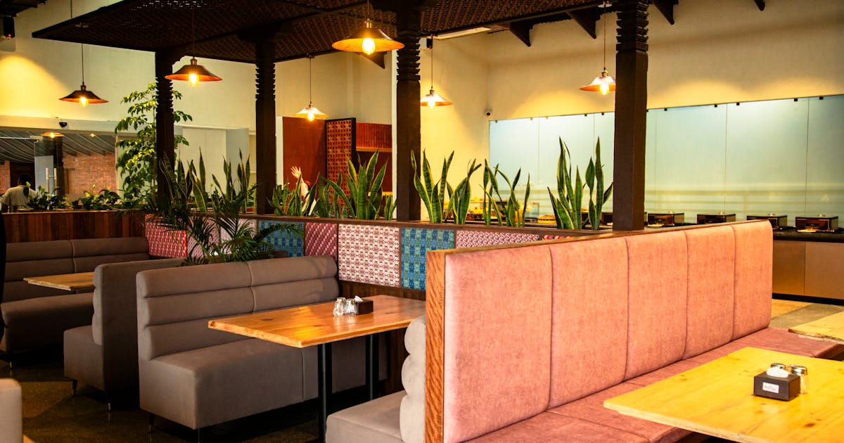 Warm Indian restaurant interior with empty booths and vibrant decor