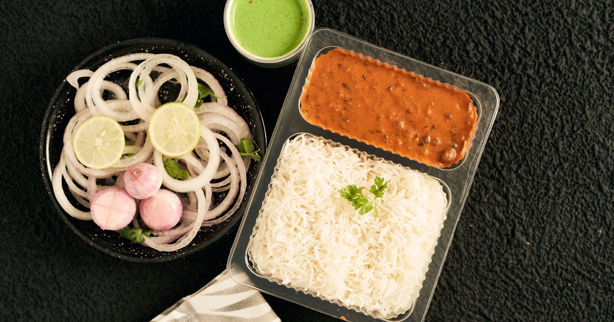 Indian takeaway meal with rice and lentils packed for delivery