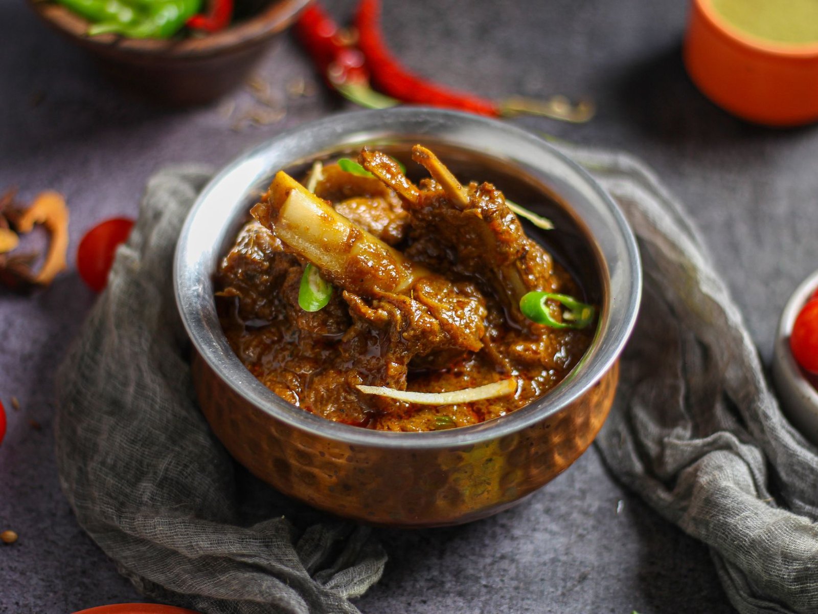 Spicy Indian mutton curry in a traditional copper bowl, a staple of Eid feast menus