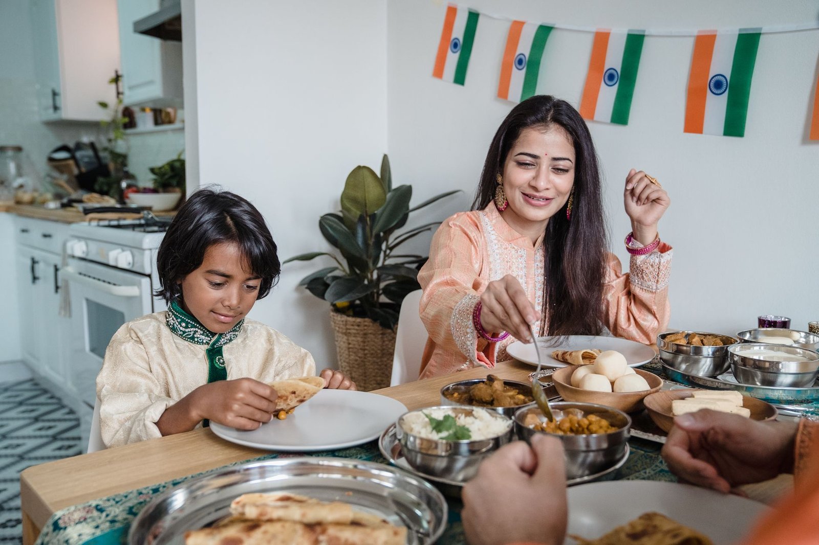 Mother and son sharing a traditional Indian meal at home, the kind of family-occasion dining a monsoon menu can pull in