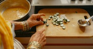 Indian cook chopping fresh vegetables in a home kitchen, illustrating safe food preparation during the monsoon season