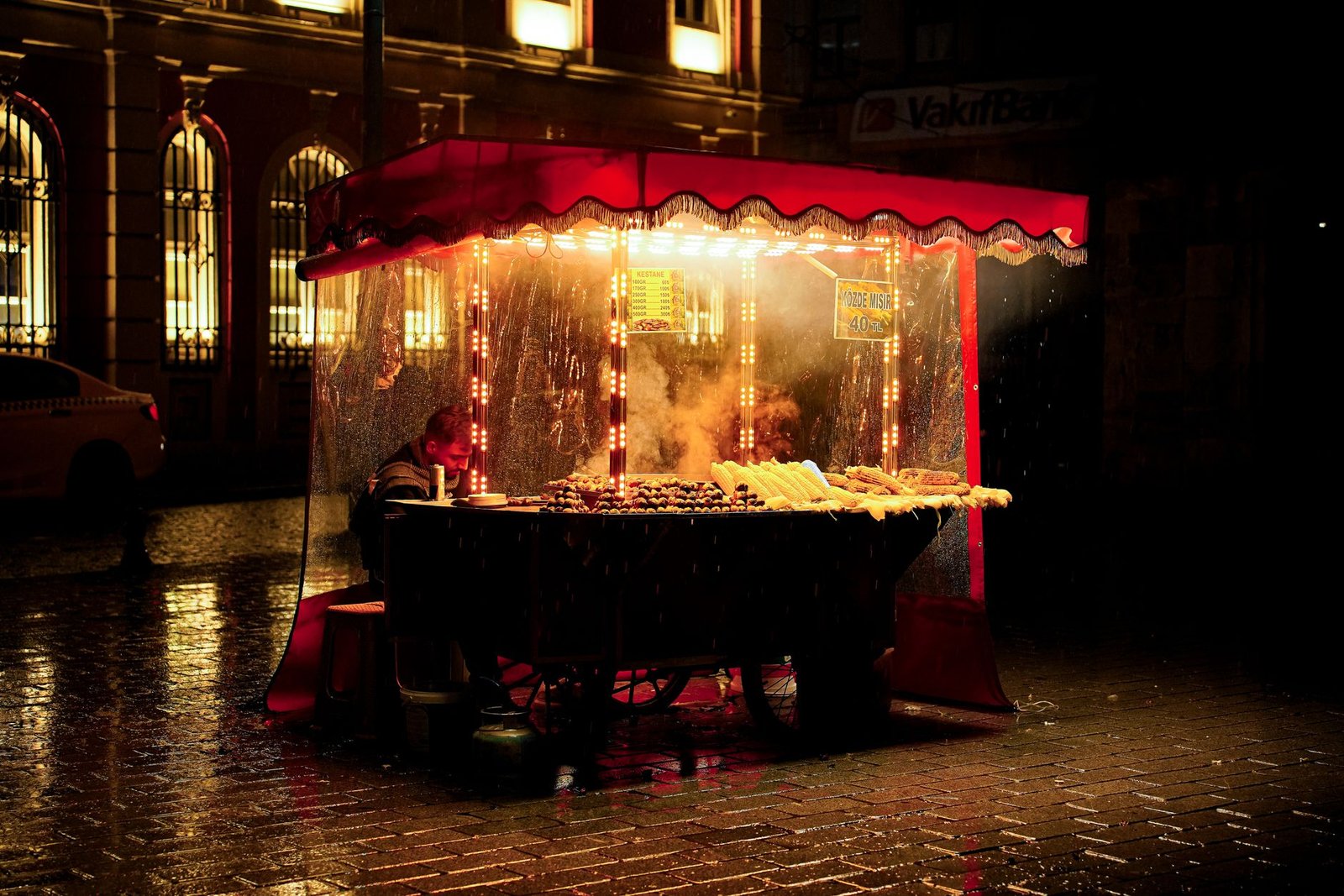 Rain-soaked Indian street food stall lit up at night, capturing the monsoon craving for hot snacks