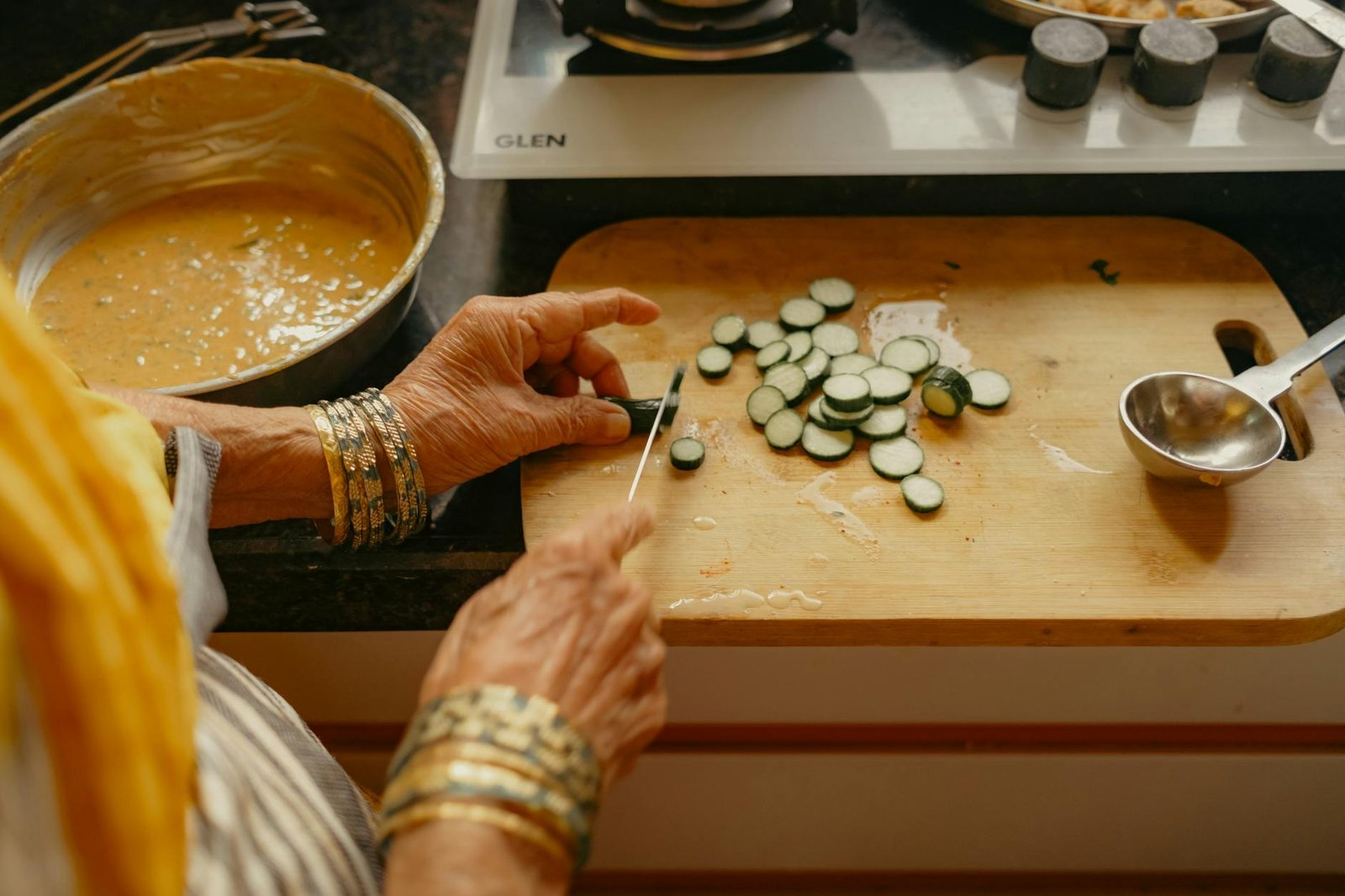 Senior Indian woman chopping vegetables in a kitchen using traditional low-waste methods