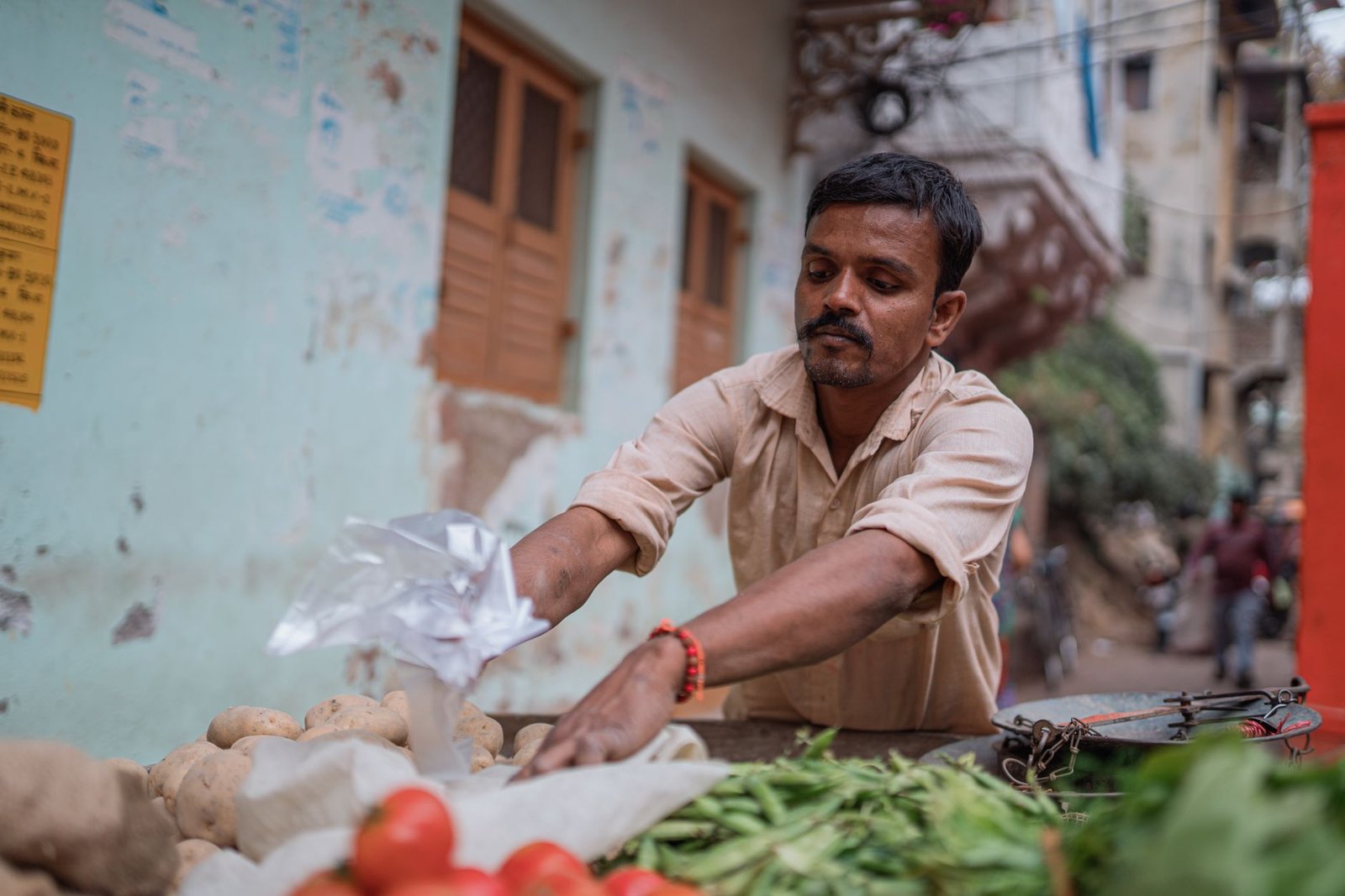 Vendor arranging fresh vegetables at a street market in Varanasi, India, showing local seasonal sourcing
