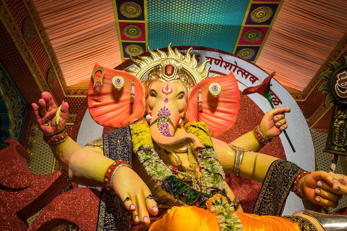 Large decorated Ganpati idol with garlands and pink ears at a Mumbai pandal during Ganesh Chaturthi