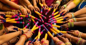 Women in colourful saris and glass bangles holding painted dandiya sticks in a circle during a Navratri garba night